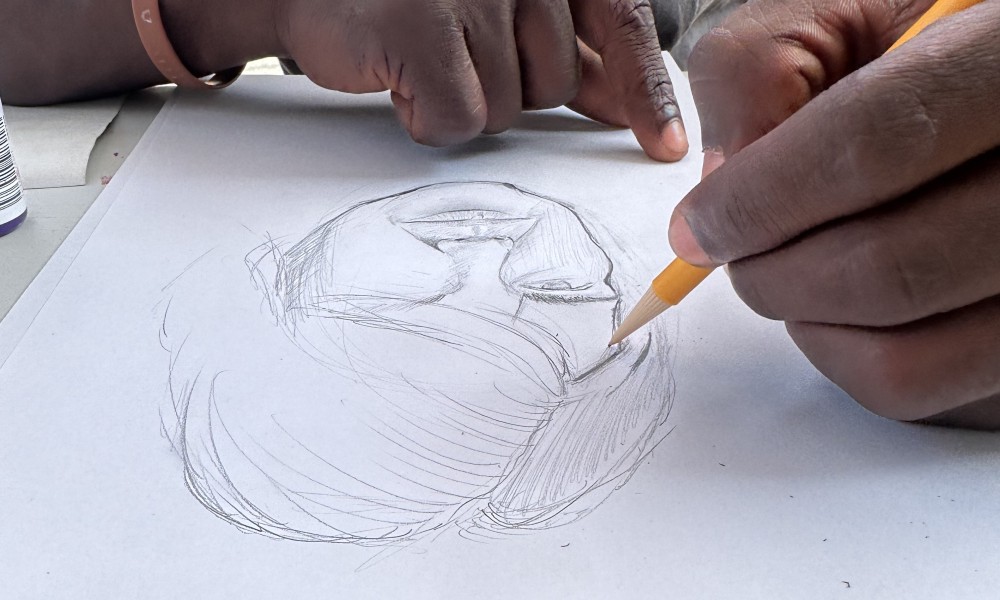 two hands. one holds a pencil and is drawing a portrait of someone with short hair. 